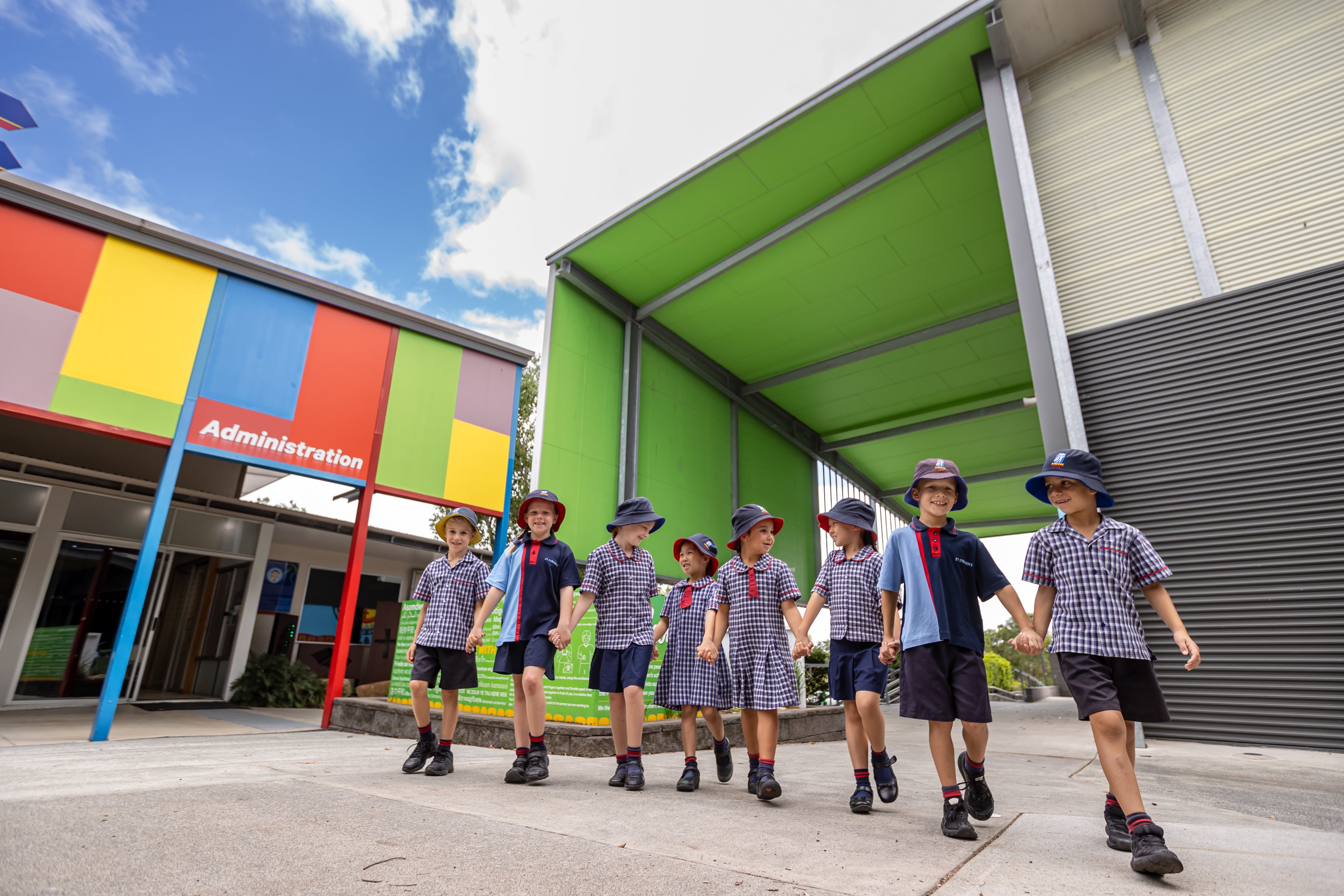 Eight primary aged students walking on school grounds.